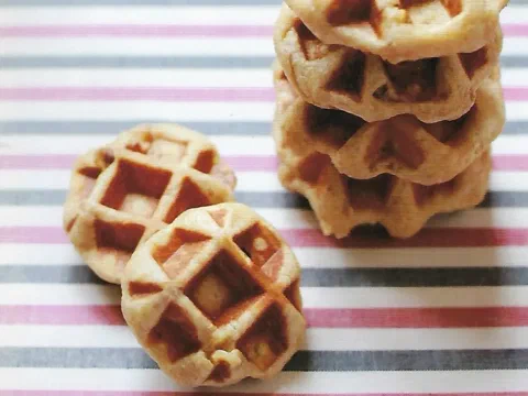 Waffles de Lieja integrales con nuez apilados sobre una tela a rayas