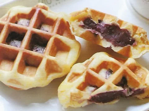 Waffle de Lieja relleno de camote morado, cortado por la mitad mostrando el relleno morado