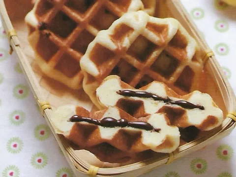Waffles de Lieja partidos con chocolate derretido saliendo del centro
