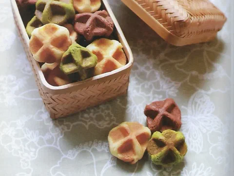 Galletas waffle en tres colores —natural, chocolate y té verde— en una canasta de bambú