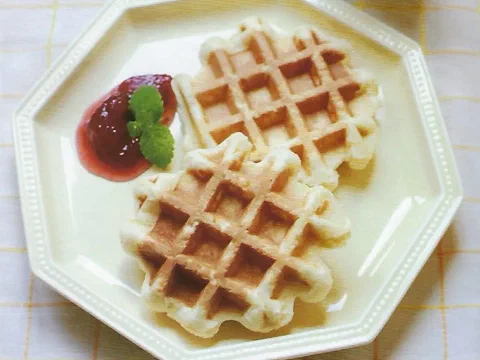 Dos scones con marca de waffle, servidos con mermelada y menta
